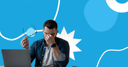 Man with a headache, rubbing his temples with his eyes closed